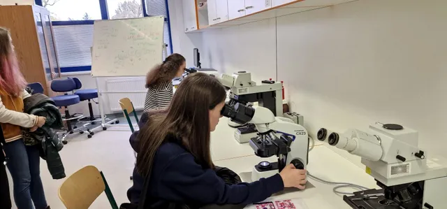Žiačka pri mikroskope v biochemickom laboratóriu